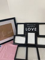 Front view of black frames including a multi-photo collage frame and single photo frames.