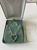 Front view of sterling silver necklace with heart-shaped amethyst pendant in green velvet box.