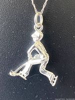 Close-up of pendant shaped as ice hockey player skating with stick.