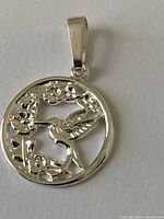 Front side view of sterling silver pendant with hummingbird and flowers design in cutout detail
