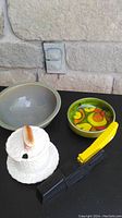 Photo of all four items showing the Wiltshire cutting utensil, the white ceramic hot dog dish, and the two MCM style serving bowls with colorful vegetable designs.