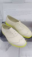 Off-white Biion shoes with neon yellow soles in original box showing side and top views.