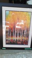 Framed oil painting showing white birch trees against an autumnal background with warm colors.