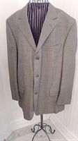 Front view of black and taupe subtle print men’s blazer on mannequin stand showing three-button closure and notch lapel.
