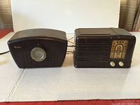 Front view of two Bakelite cased electronics side by side on white surface: Bogen television booster on left, General Electric radio on right