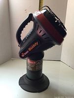 Front and side angle view of Coleman Little Buddy heater showing handle, base, and branding details