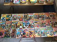 Wide view of 30 vintage western comic books laid out showing covers including Rawhide Kid and others