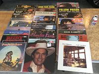 Overview of 27 country music LP records showing multiple artists and titles arranged in rows on a floor.