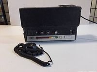 Full view of Roland TR-55 Rhythm Box drum machine with coiled cable and external trigger switch