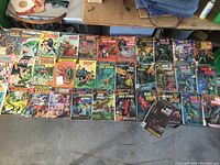Photo showing a spread of 34 vintage comic books including Tarzan, Korak Son of Tarzan, Boris Karloff, Dagar the Invincible and Grimm's Ghost Stories.