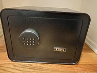 Front view of the black Edge safe showing the keypad and logo plate.