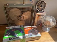 Photo showing all items in the lot including fans, heater box, and massager boxes