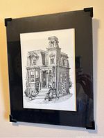 Framed detailed ink drawing of a Victorian house, showing full view with black mat and protective corners.