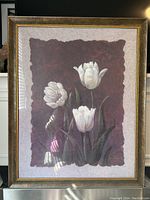 Full view of the framed print showing three white tulips against a dark maroon textured background inside a gold frame.