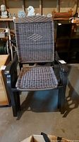 Single brown metal framed patio chair with woven wicker style back and seat shown facing forward, clear view of armrests and seat weave pattern.