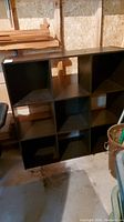 Front view of the black shelving unit showing 9 empty cubbies arranged 3 by 3 about 36x36 inches square and 12 inches deep.
