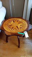 Front and top view of the wood side table showing compass marquetry design on the tabletop.