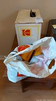 Photo of the original Kodak box along with a plastic bag containing additional items related to the projector.