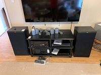 Pair of Citizen speakers positioned on floor, side view showing black cloth front grill and overall condition.