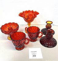 Amberina glass lot including two sugar and creamer cups, a ruffled compote, hobnail candy dish, and two hobnail candle holders