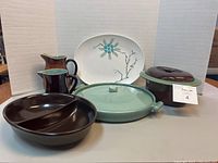 Photo showing the entire lot of vintage serveware including pitchers, divided dish, casserole dish, and platter
