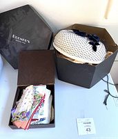 Photo showing the vintage hat in a Bremer's hatbox alongside an open box containing multiple vintage handkerchiefs with floral prints.