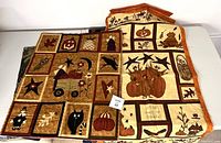 Two unfinished quilts with seasonal fall and Halloween applique designs suitable for hanging on a wall.