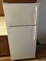 Frigidaire white refrigerator closed, showing front exterior with two doors and handles.