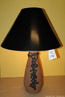 Full view of the handmade studio pottery table lamp with black shade, showing front profile.