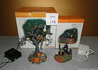 Two boxed Halloween Village accessories from Department 56 with power adapters and cords visible.