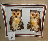 Pair of vintage owl chalkware wall plaques in original packaging, showing both plaques side by side with detailed painted features and bright orange eyes.