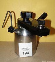 Front-left side view of Elebak stovetop espresso maker showing black handle, lid knob, and steam wand spout.