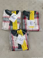 Three boxed multi holiday plaid infant pajama sets in original packaging