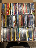 Box containing multiple rows of DVD cases showing various titles