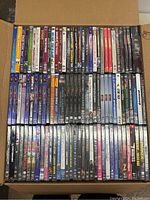 Top-down view of DVDs arranged in rows showing a variety of movie titles and genres in their cases.