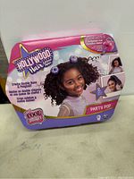Front of the Hollywood Hair Extension Maker kit showing branding, child model, and description of the product