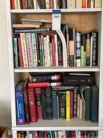 Full view of five shelves on left side filled with assorted books