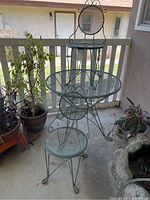 Full view of the green metal mesh patio table with two chairs on porch
