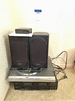 Full stereo system setup showing paired Pioneer speakers, receiver, turntable, and an external small unit on top of one speaker, all on carpeted floor.