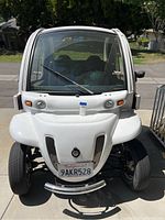 Front exterior view showing white body, curved windshield, and front bumper