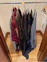 Rack view of seven kimono-style jackets and tops hung on a rail