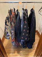 Group shot of six kimono style garments on wooden hangers