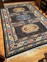 Full view of the rug on hardwood floor showing overall pattern and condition.