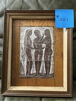 Front view of the framed carved artwork showing three female figures and the frame detail.
