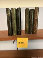 Full view of both bookends placed side by side showing the cylindrical clustered brutalist style sculpture and multicoloured stone textures.