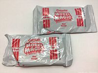 Two sealed packs of Crayola Model Magic modeling material in red, each 28g, showing front packaging with product name and details.