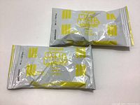 Two unopened packs of Crayola Model Magic modeling material in yellow, each pack showing packaging details and weight (28 grams).