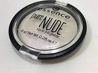 Top view of Essence Pure Nude Spacelighter highlighter compact showing product name and net weight 8g/0.28oz.