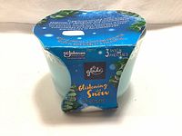 Blue wax candle in clear glass container with original blue packaging indicating Glade brand and Glistening Snow fragrance.