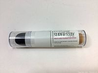 Photo of the Maybelline Super Stay Multi-Use Foundation Stick with clear cap showing the product label and shade 130 Buff Beige.